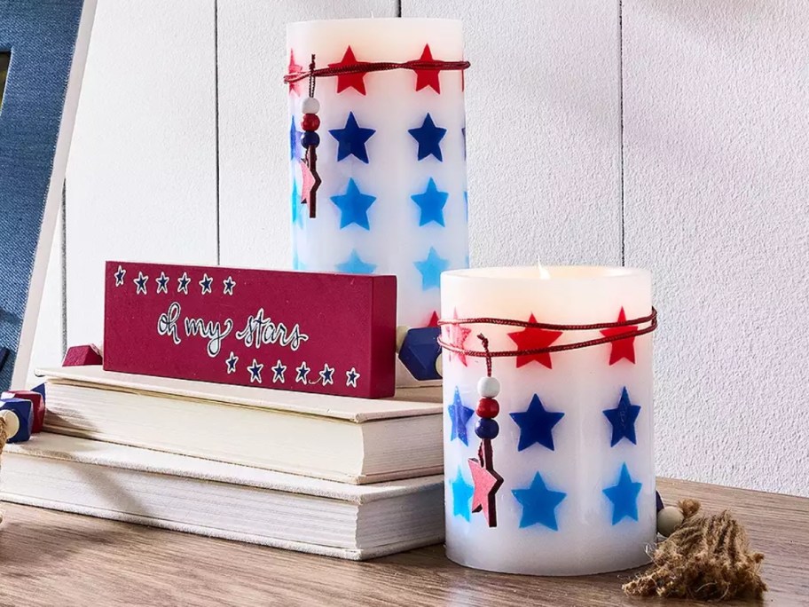 patriotic pillar candles with red and blue stars on a console table
