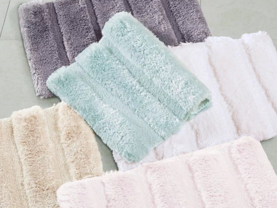 tufted bath mats in various colors and sizes on a floor
