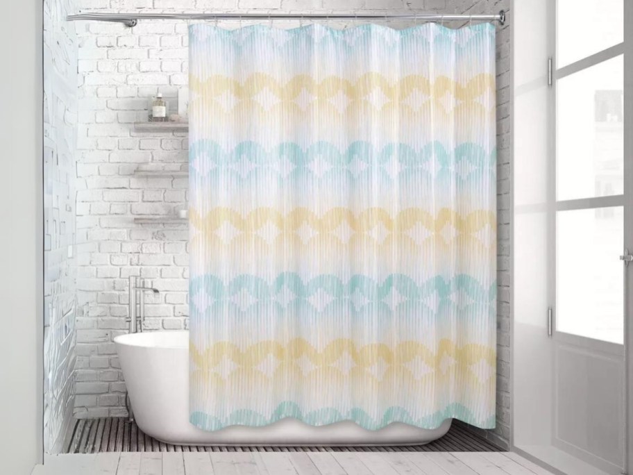 blue, yellow and white ombre shower curtain hanging on a shower