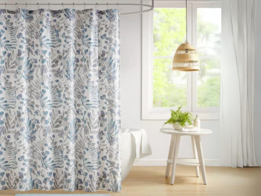blue floral seersucker shower curtain on a shower in a bathroom