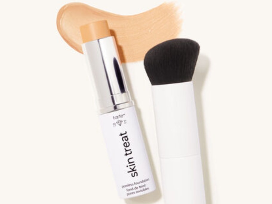 tube of foundation next to a brush, with some foundation spread out