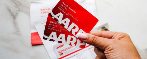 hands holding red aarp cards
