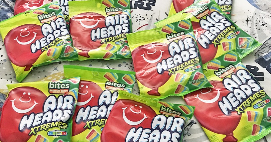 multiple small bags of Airheads Candy Xtremes Bites laid out on bed
