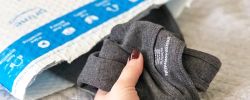 hand taking a grey tank top out of amazon bag