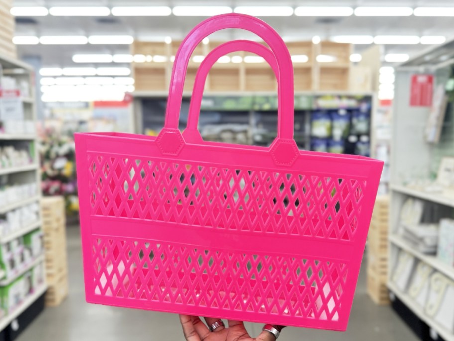 hand holding up a pink jelly tote in store