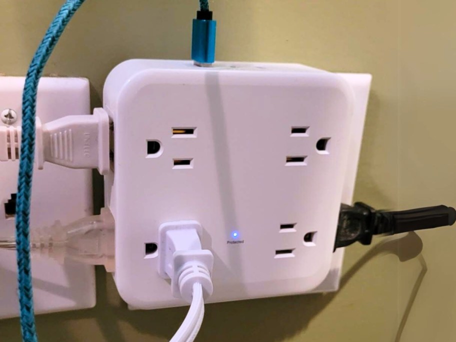 wall outlet extender with various electronics and USB cables plugged into it