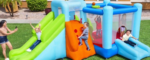 kids playing on inflatable bounce house with slides