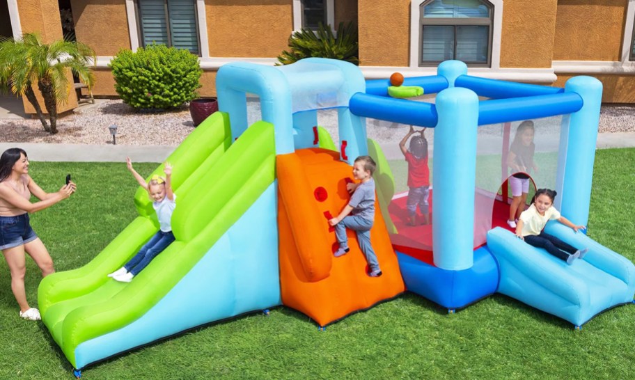 kids playing on inflatable bounce house with slides