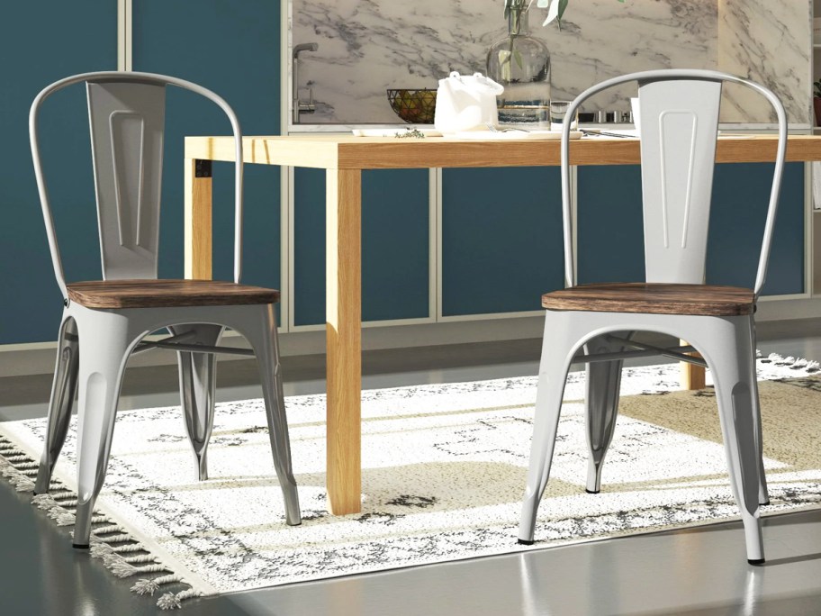 two grey metal dining chairs with wood seats