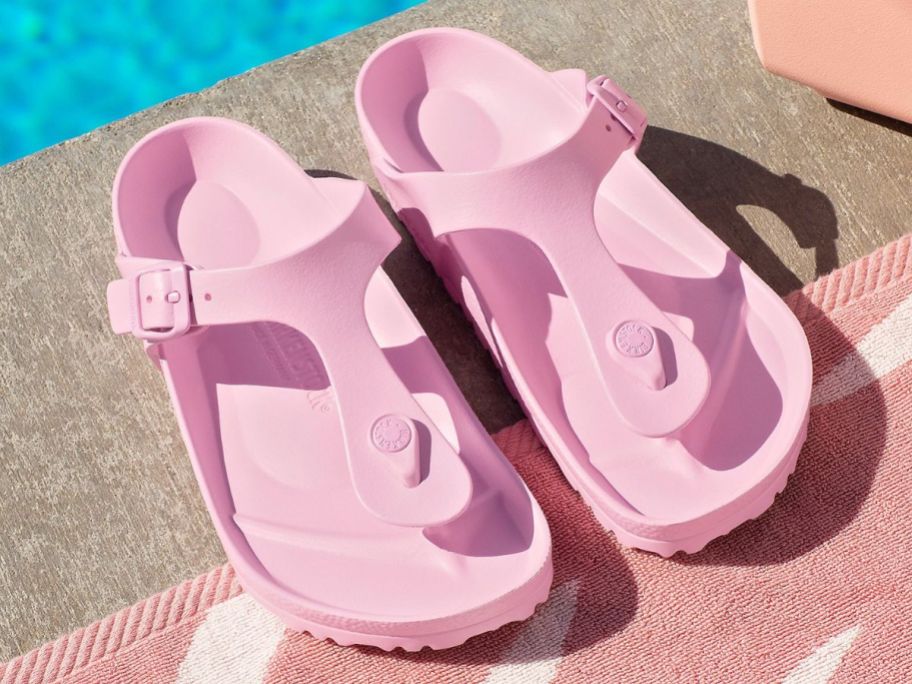 A pair of Birkenstock thong sandals by a pool