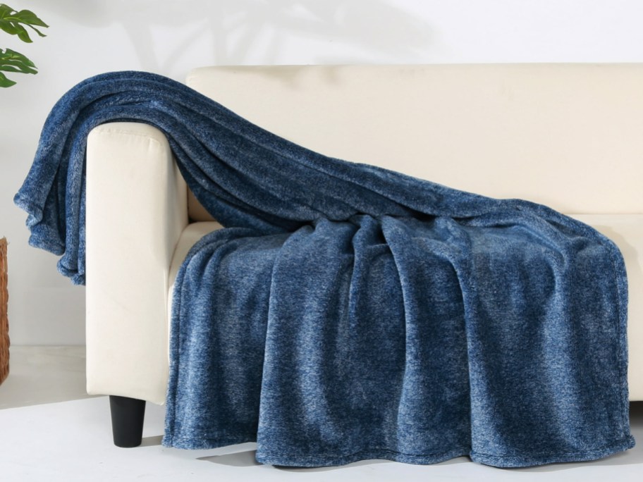 Blue color throw blanket displayed on a couch