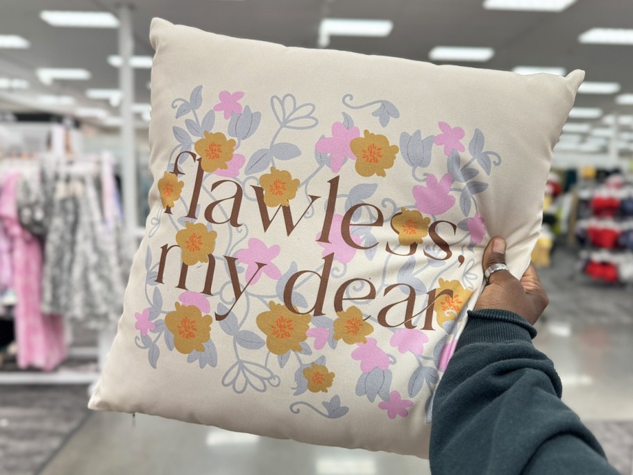 hand holding up a floral print throw pillow that says flawless my dear