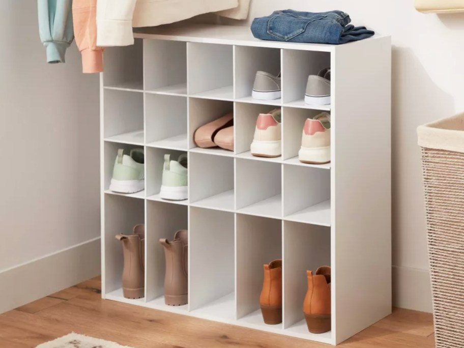 white shoe cubby organizer filled with shoes in closet