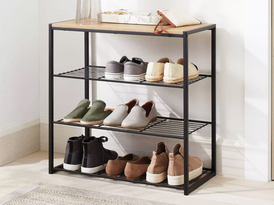 shoes on a black metal shoe rack with wood top