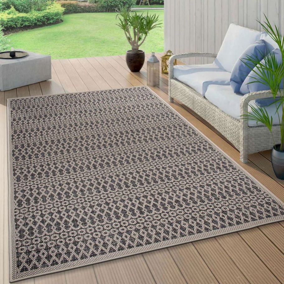a cream and gray geometric patterend rug on a patio