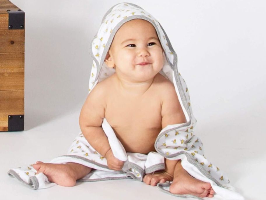 A baby wearing a Burt's Bees hooded Bath Towel