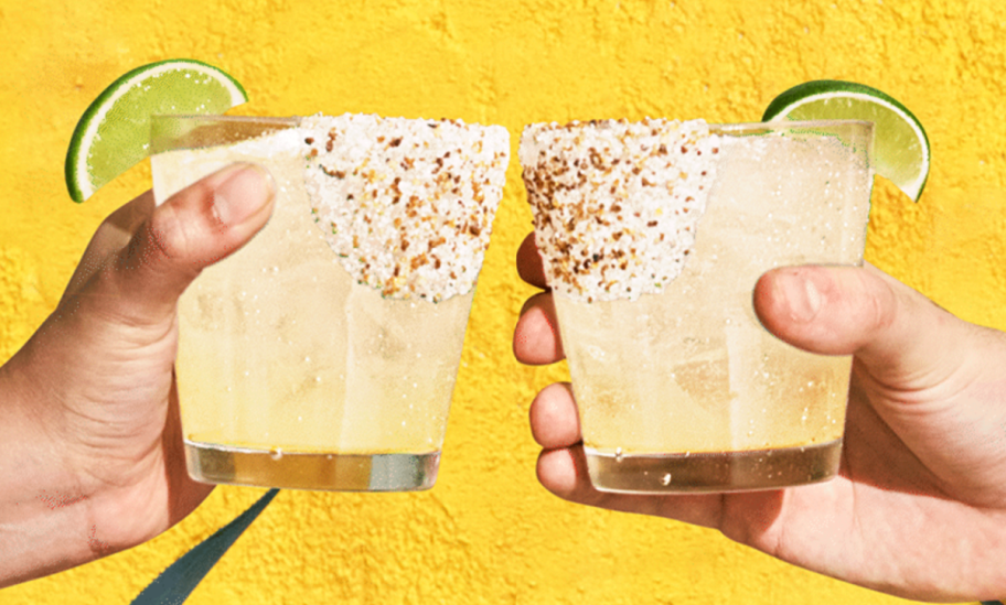 two hands clinking glasses of Chili's Trifecta Tequila