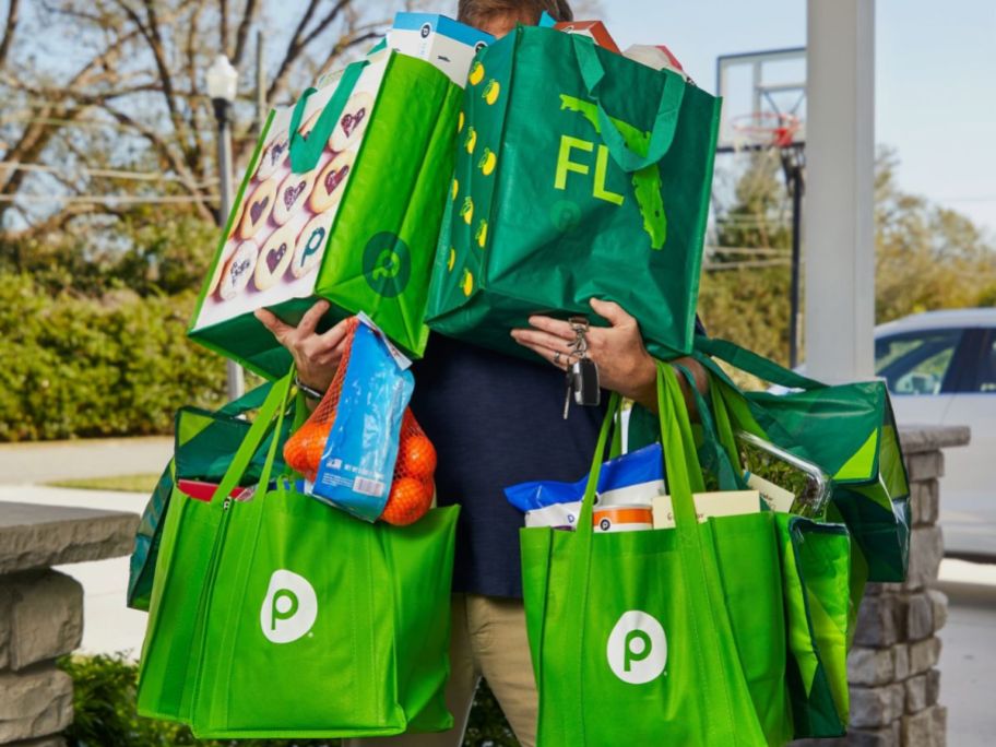 Man carrying a bunch of Publix shopping bags
