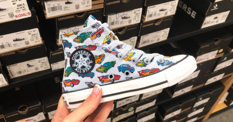 hand holding up a high top converse car-print sneaker in store