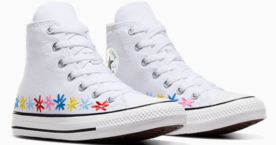 pair of white converse high top sneakers with multi colored flowers along the bottom