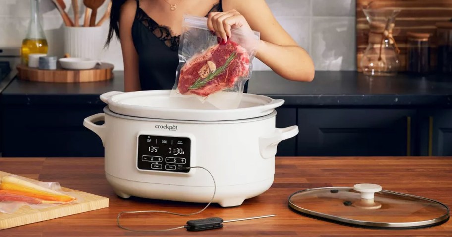 placing bagged steak into crock-pot to cook with sous vide
