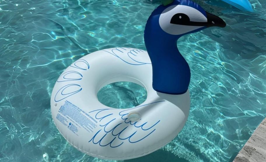 an inflated peacock pool float floating in a pool