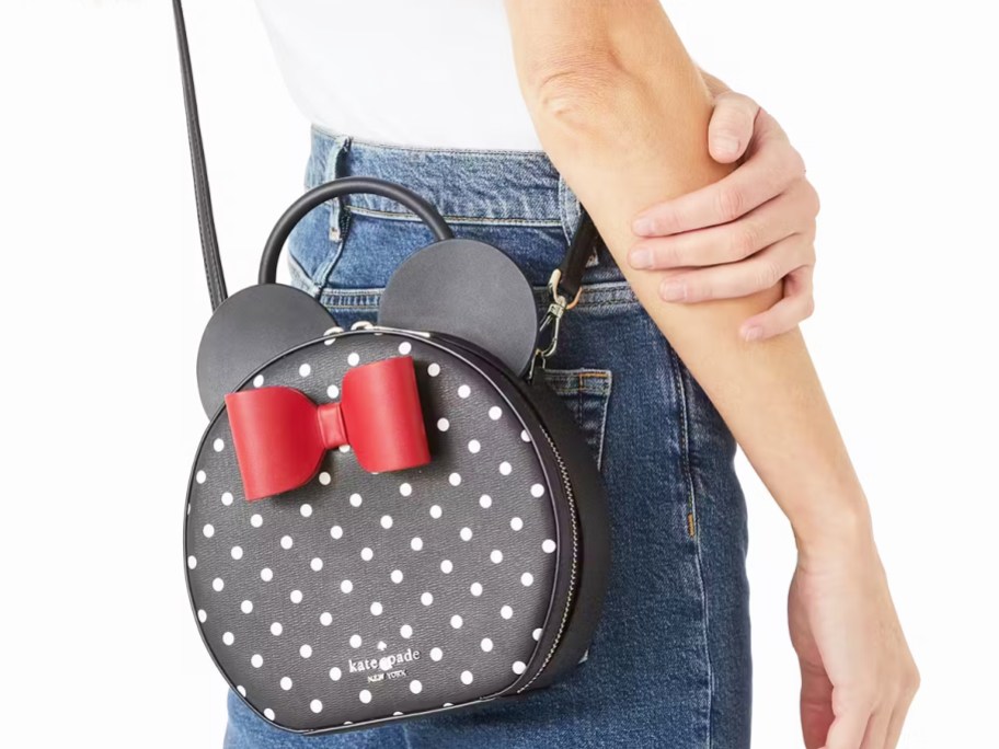 woman in jeans and white top with a black minnie mouse crossbody bag