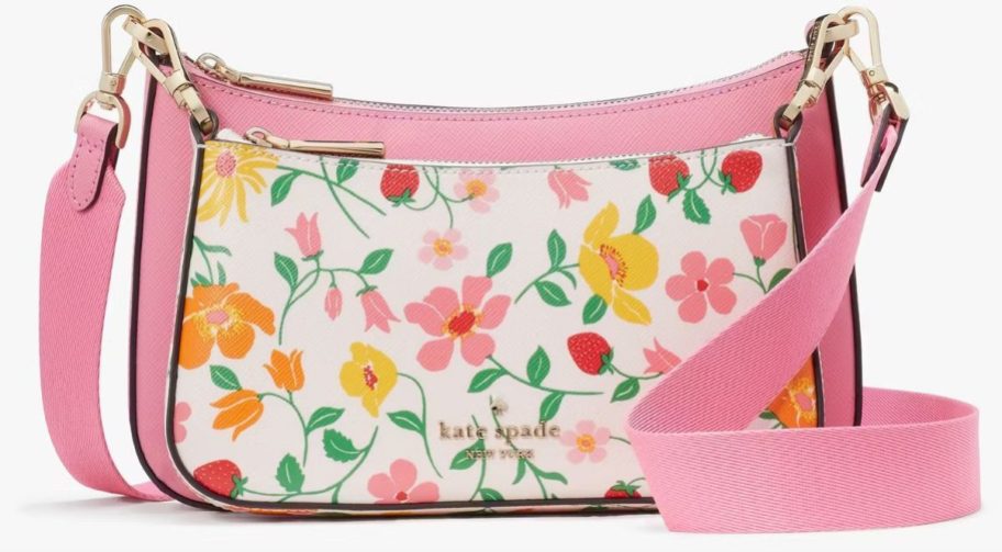 a floral print crossbody bag with pink trim n a white background