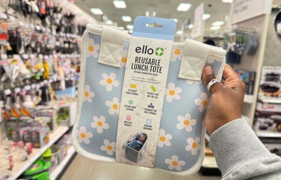 a womans hand holding an Ello reusable food container tote 