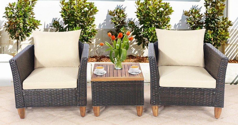 brown rattan patio chairs with white cushions and matching side table