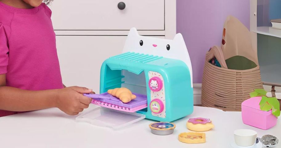 girl playing with Gabby's Dollhouse Bakey with Cakey Oven Kitchen Toy