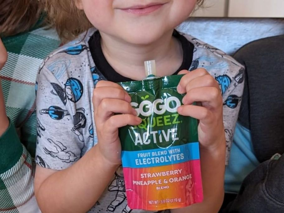 Child holding a pouch of GOGO Squeez Active