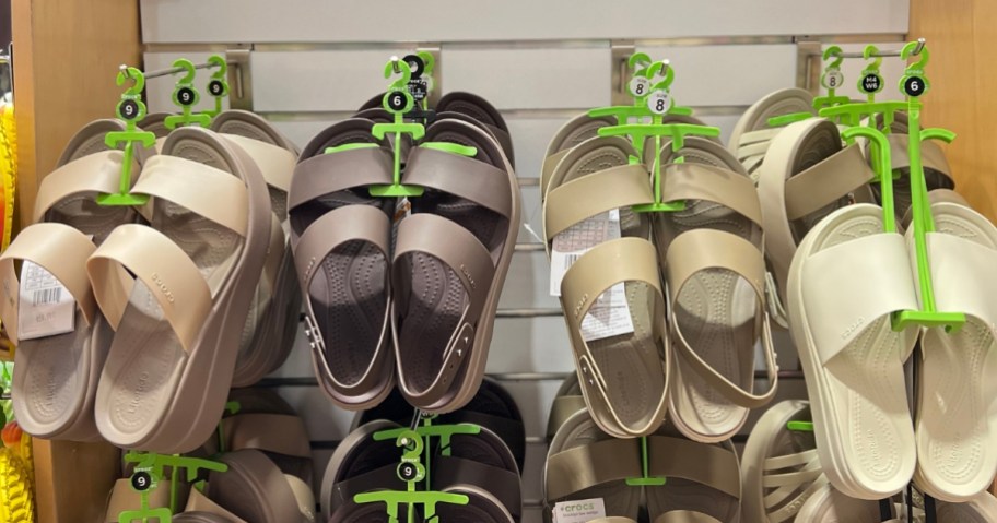 tan, bone, brown, black women's Crocs sandals and slides on display in Crocs store
