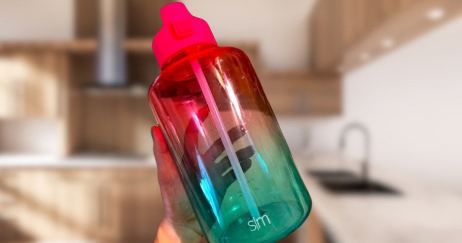 hand holding a pink and teal large Simple Modern water bottle
