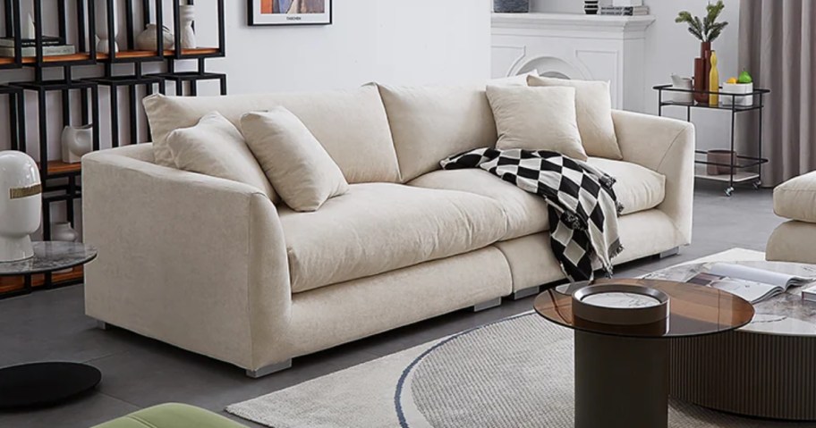 beige sofa in a modern style living room with a black and white throw blanket hanging off it