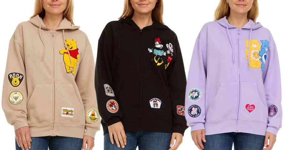 3 women wearing character zip up hoodies with Winne the Pooh, Mickey & Minnie and Care Bears designs