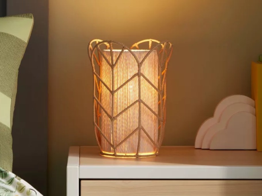 boho style tulip rattan cylinder lamp on a bedside table