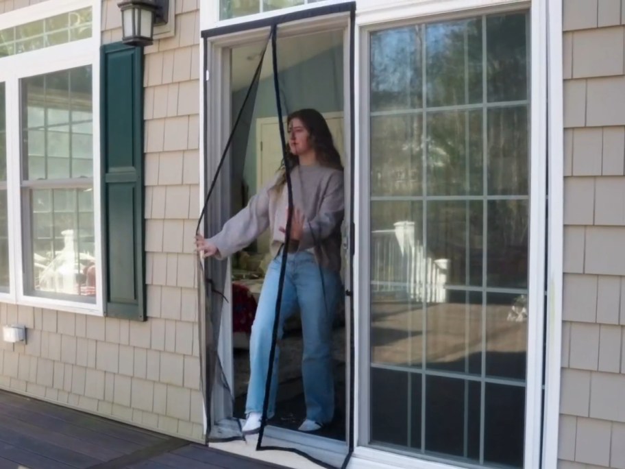 woman walking thru a magnetic screen door on a house