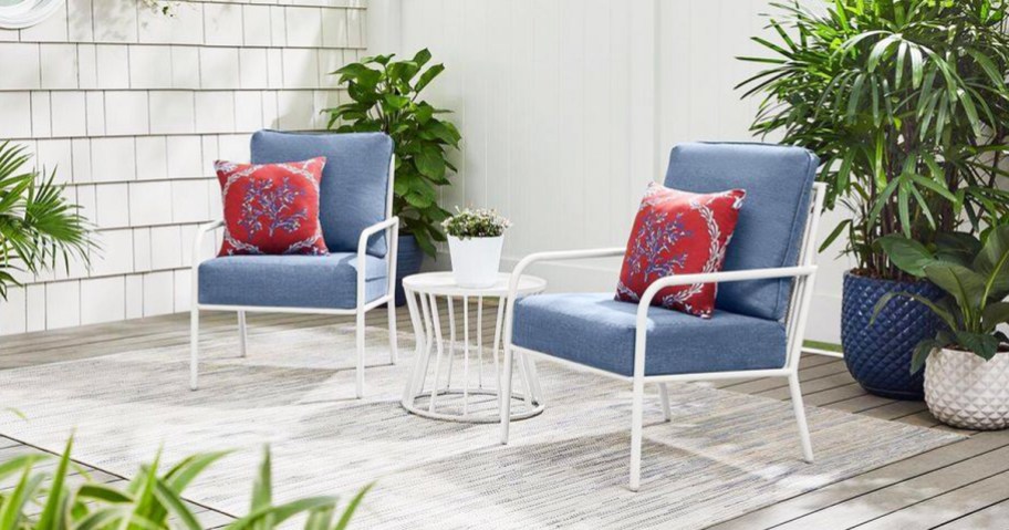 white metal chairs with blue cushions and matching side table