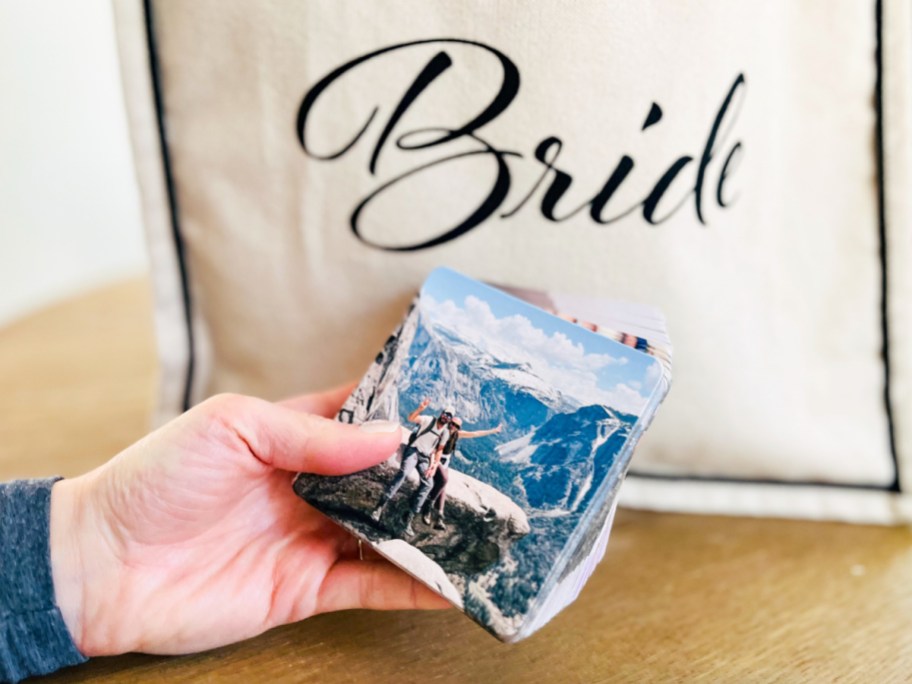 Hand holding bride drinking coasters with bride behind it
