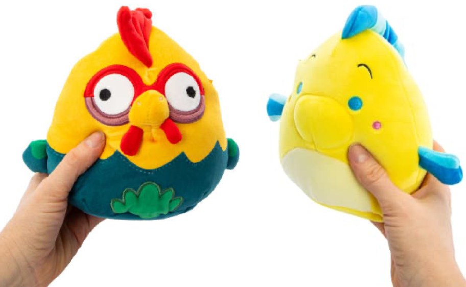 Hand holding squishmallow flounder and hei hei