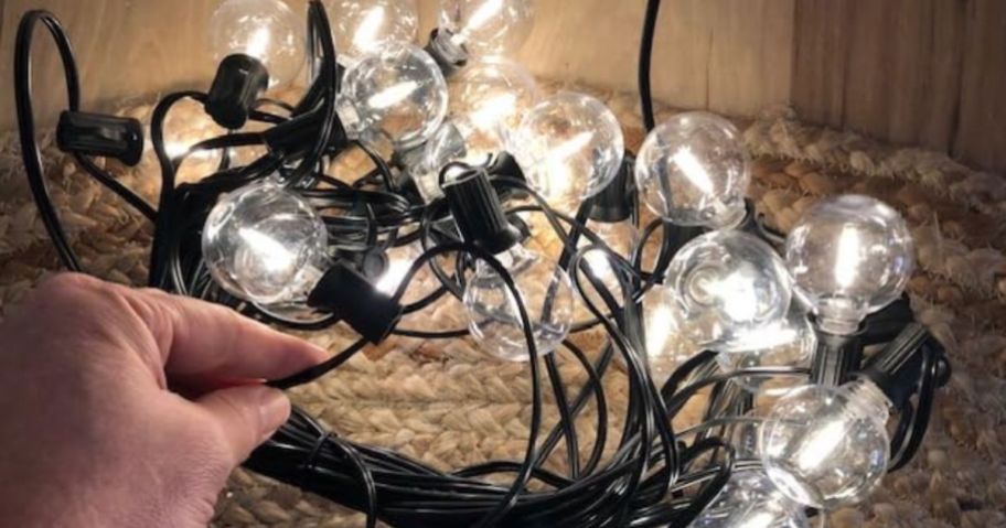 A hand holding Handwell 100FT Outdoor G40 LED Globe String Lights