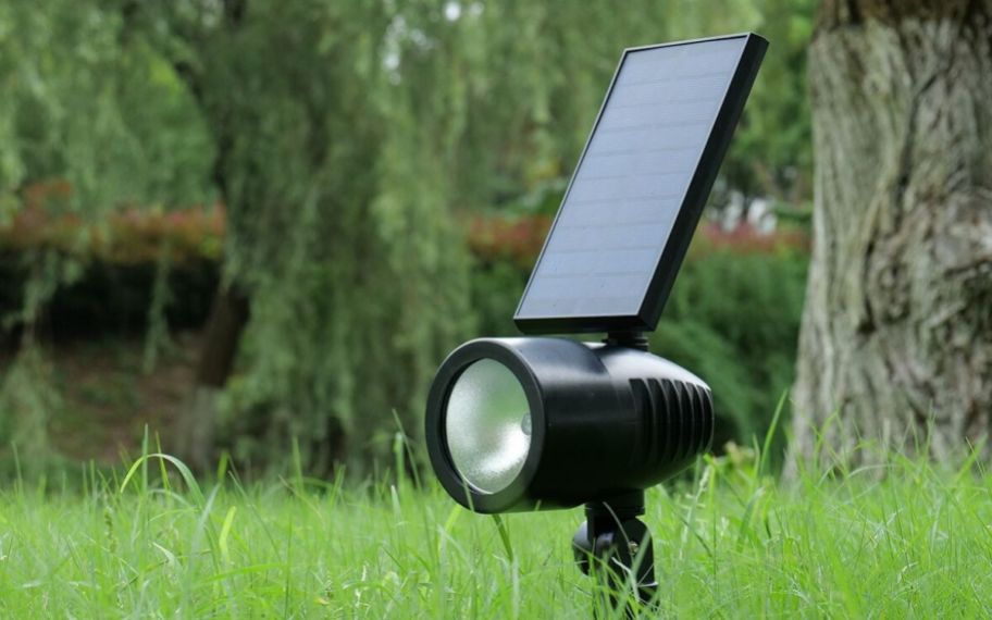 a solar led flood light staked into the ground in a yard