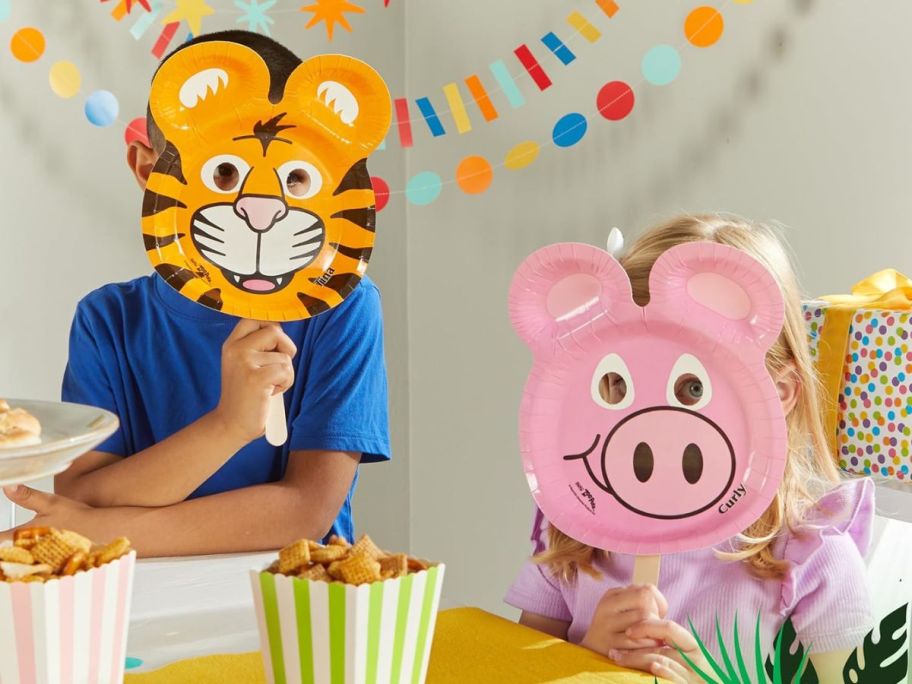 children holding Hefty Zoo Pals Party Edition Paper Plates for Kids, Assorted Animal Designs, 7.75 Inches with Two Dipping Compartments in front of their faces at party