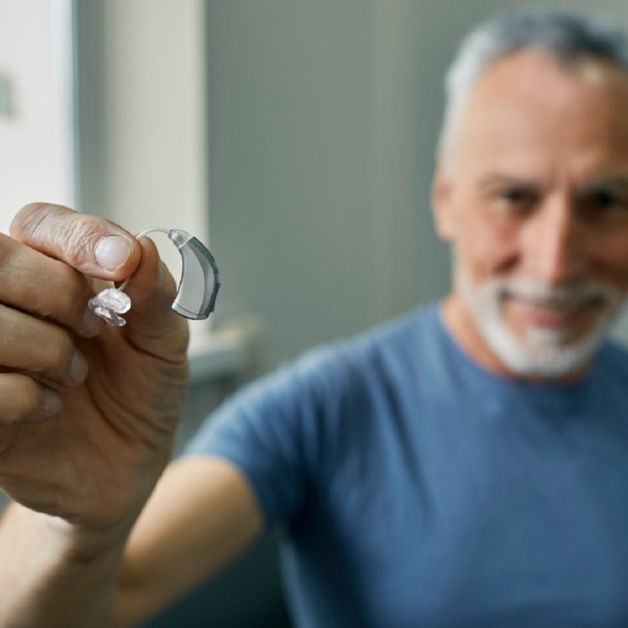 man holding up a hearing aid