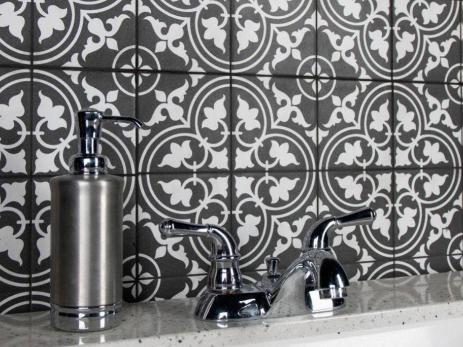 A sink with xMerola Tile Harmonia Classic Black Ceramic Floor & Wall Tile  in the background