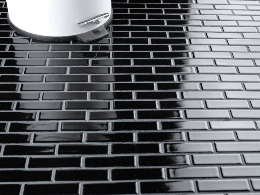 A floor with Merola Tile Metro Brick Subway Glossy Black Porcelain Mosaic Tile