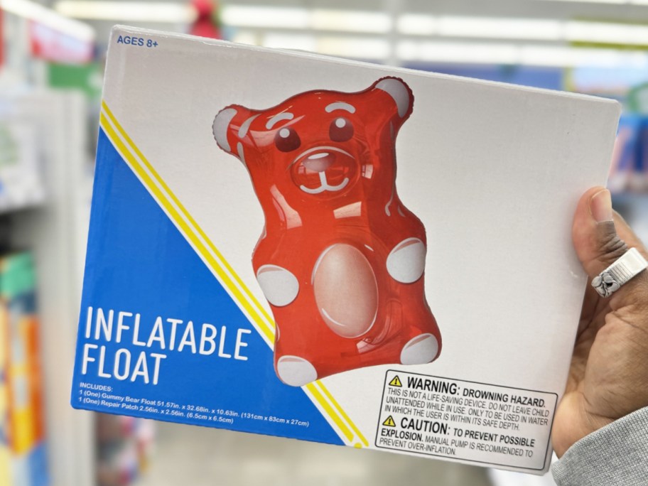 hand holding up a red gummy bear shaped pool float