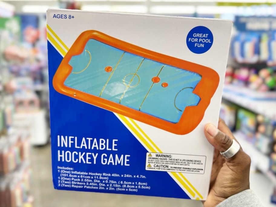 hand holding up a blue and orange Inflatable Hockey Pool Game
