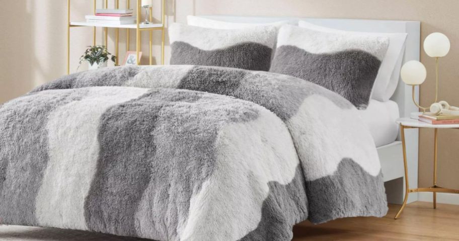 A bed with an Intelligent Design Rachel Ombre Shaggy Faux Fur Comforter Set in gray